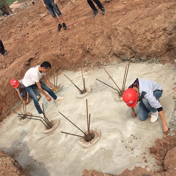 图为学徒在师傅指导下测放承台轴线.jpg